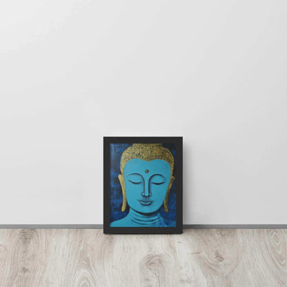 A framed poster with a black oak finish features a serene Blue Buddha Zen Wall Art with golden touches, set against a darker blue backdrop with a rich, textural finish, positioned on a light wooden floor by a plain white wall.