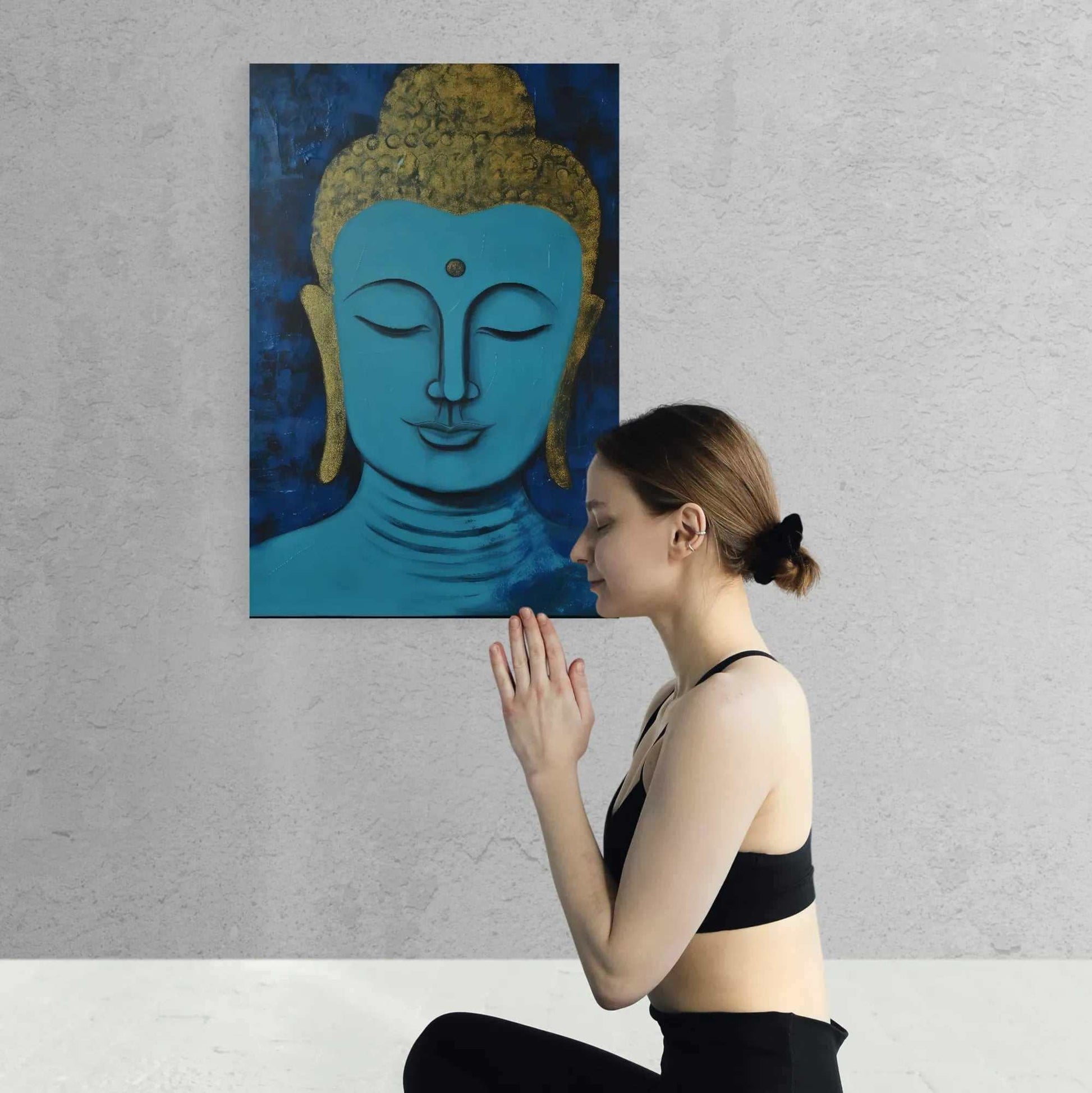 Woman in meditation pose in front of a Buddha painting, adding a peaceful aura to a minimalist space with textured walls.