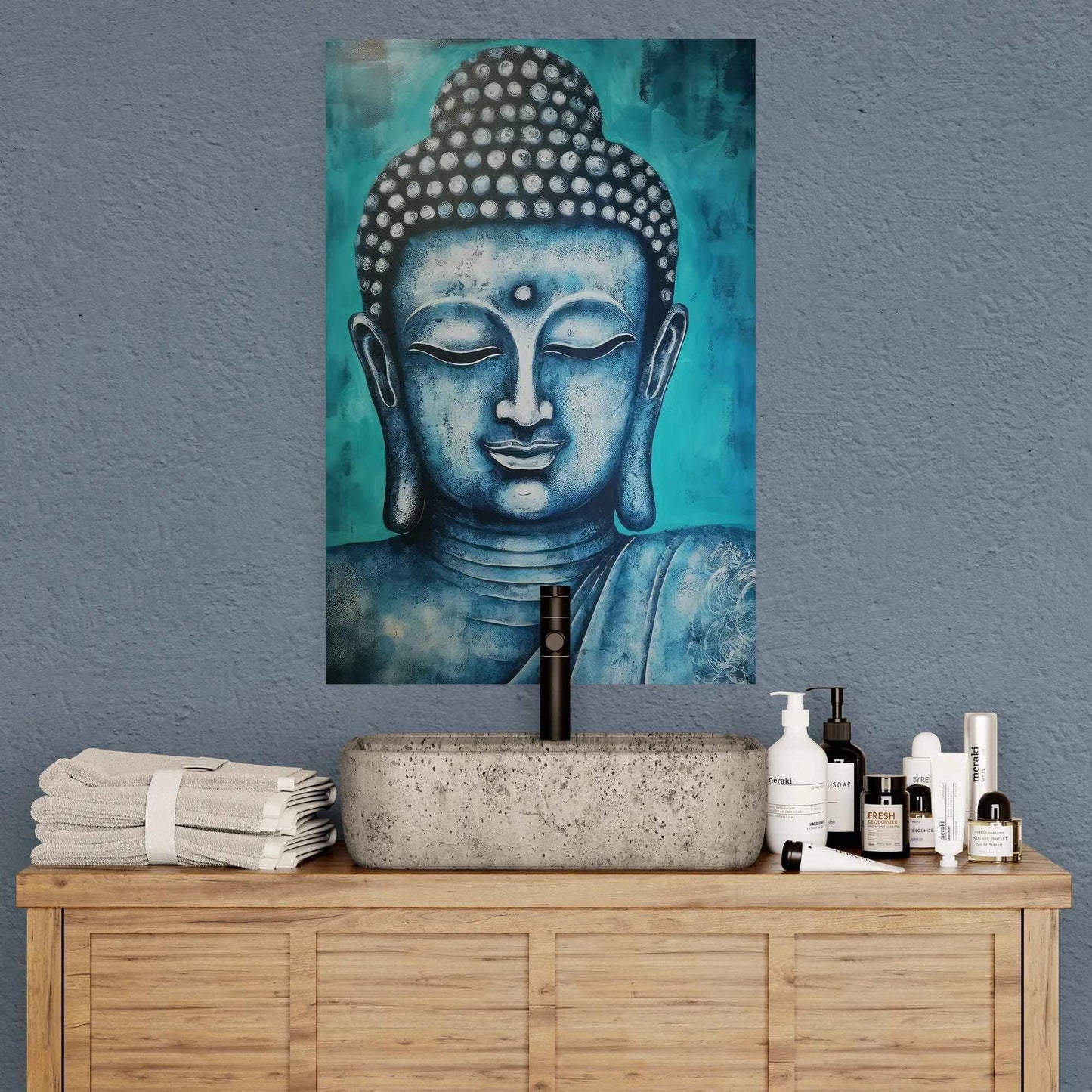 Sophisticated bathroom featuring a stone basin on a wooden vanity with neatly folded towels and toiletries, under a blue and gold Buddha head painting.