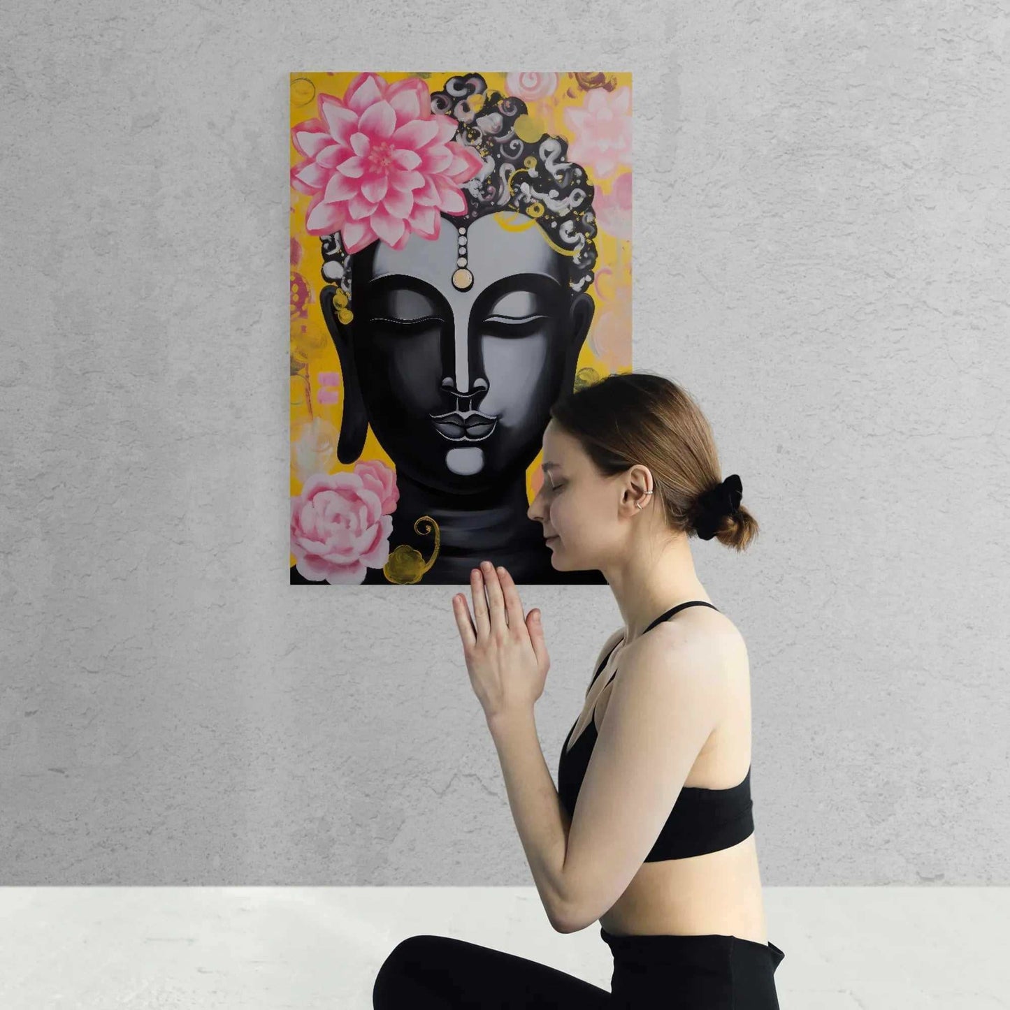 Woman in a meditative pose in front of a vibrant Buddha painting with floral designs and a yellow background, radiating a sense of peace.
