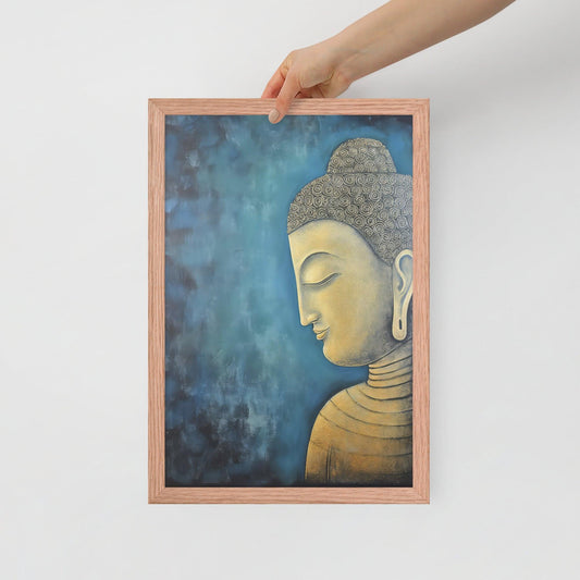 A hand is placing a framed poster on a white background, where a serene Golden Buddha Art with a patterned head and golden features is portrayed in profile against a mottled blue backdrop, all within a red oak frame.