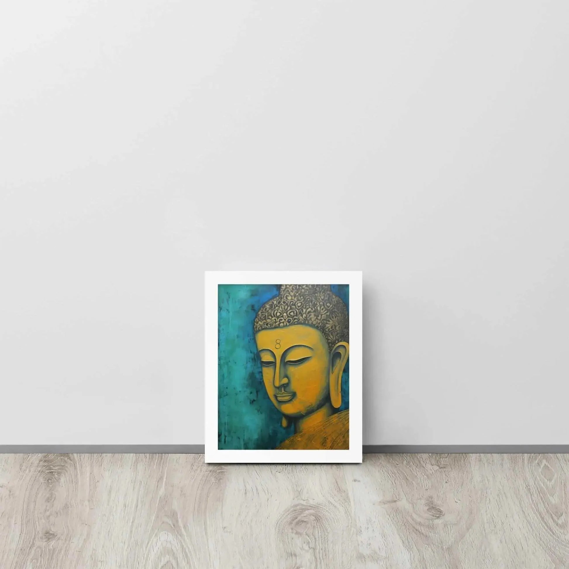 A white oak framed Golden Buddha Painting poster featuring a close-up of a serene Buddha's face with a golden complexion against a textured turquoise background is presented on a light wooden floor beside a white wall, embodying a blend of spirituality and modern art aesthetics.