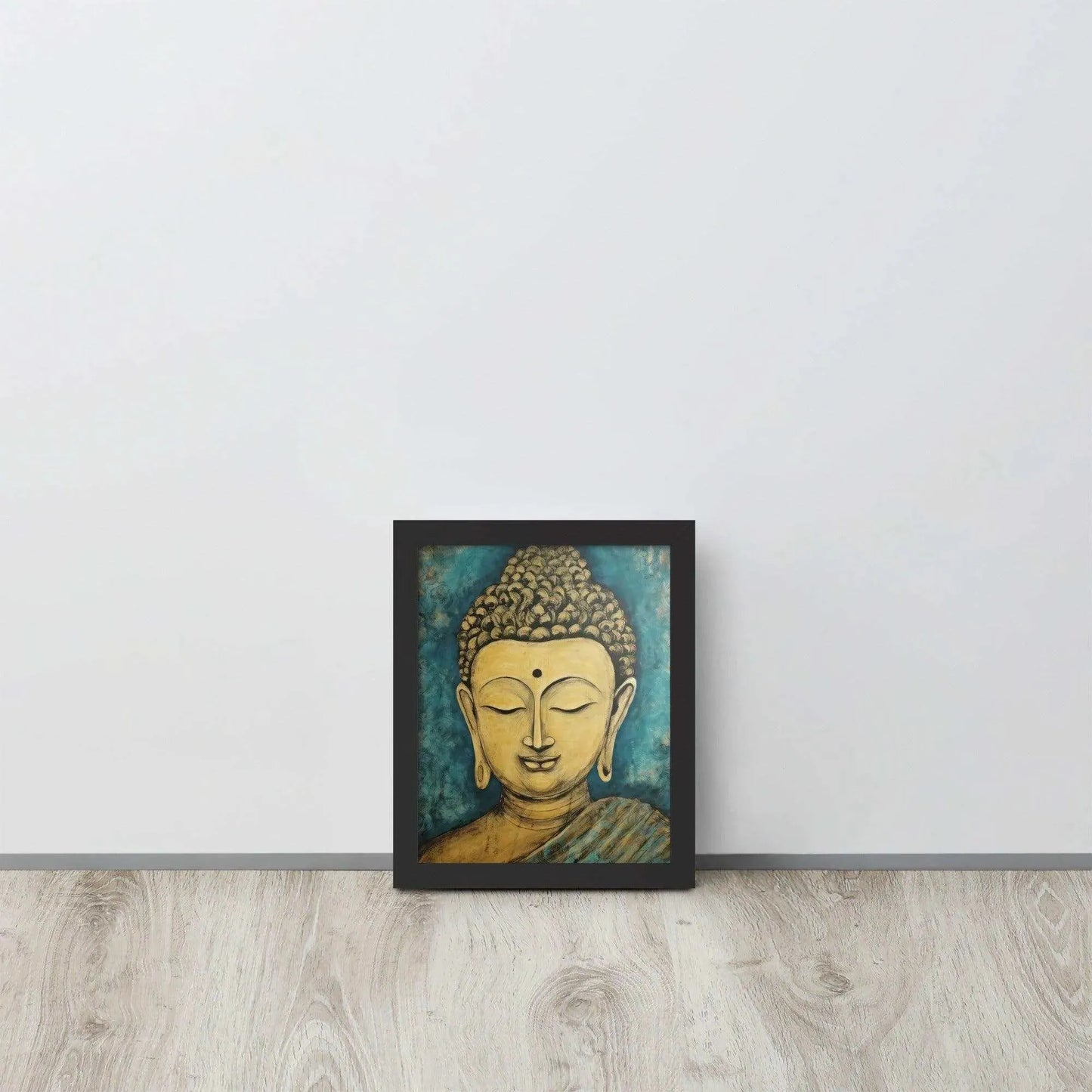 A black oak framed poster on a light wooden floor features a Golden Buddha Zen Wall Art with a tranquil expression, set against an abstract blue textured background, conveying a sense of peace and introspection beside a white wall.