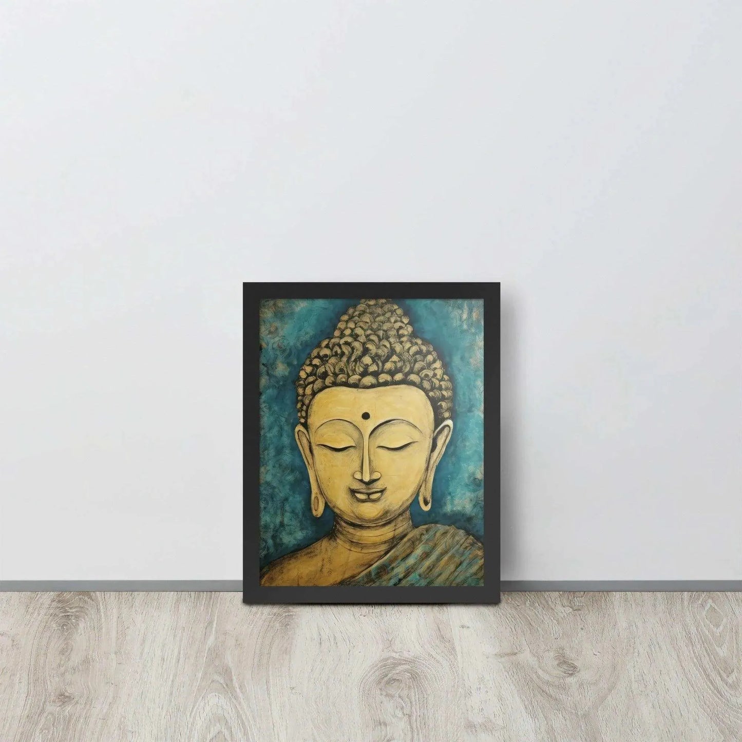 A black oak framed poster on a light wooden floor features a Golden Buddha Zen Wall Art with a tranquil expression, set against an abstract blue textured background, conveying a sense of peace and introspection beside a white wall.