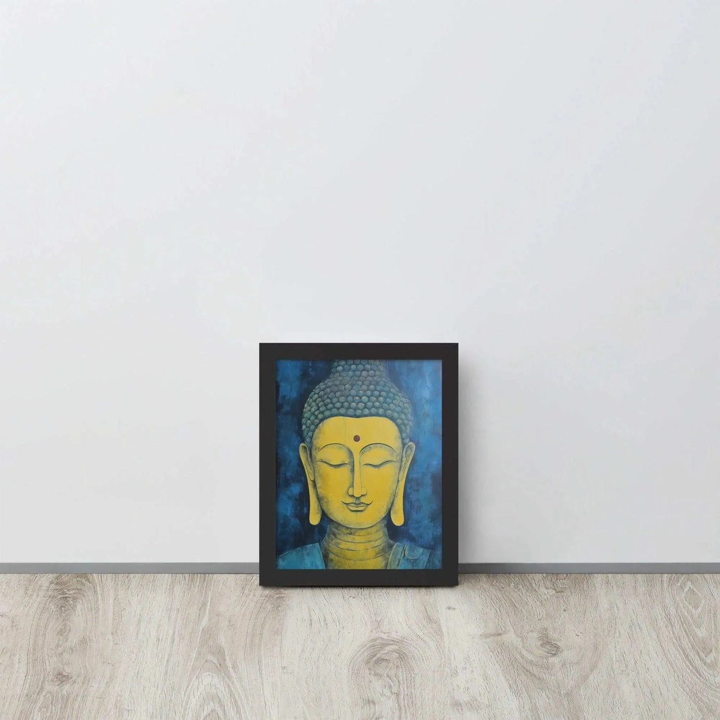 A black-Golden Happy Buddha Framed Print placed on a wooden floor against a white wall features a golden Buddha head with a serene expression, set against a deep blue textured background, creating a focal point of tranquility and spirituality in the room.