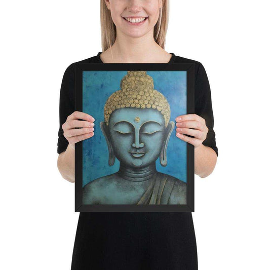 A beaming woman is holding a black-Happy Buddha Framed Print that features a Buddha head painted in shades of blue and gold against a textured blue background, exemplifying a fusion of traditional iconography with a modern artistic twist.