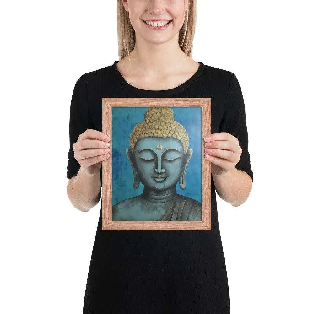 A beaming woman is holding a red-Happy Buddha Framed Print that features a Buddha head painted in shades of blue and gold against a textured blue background, exemplifying a fusion of traditional iconography with a modern artistic twist.