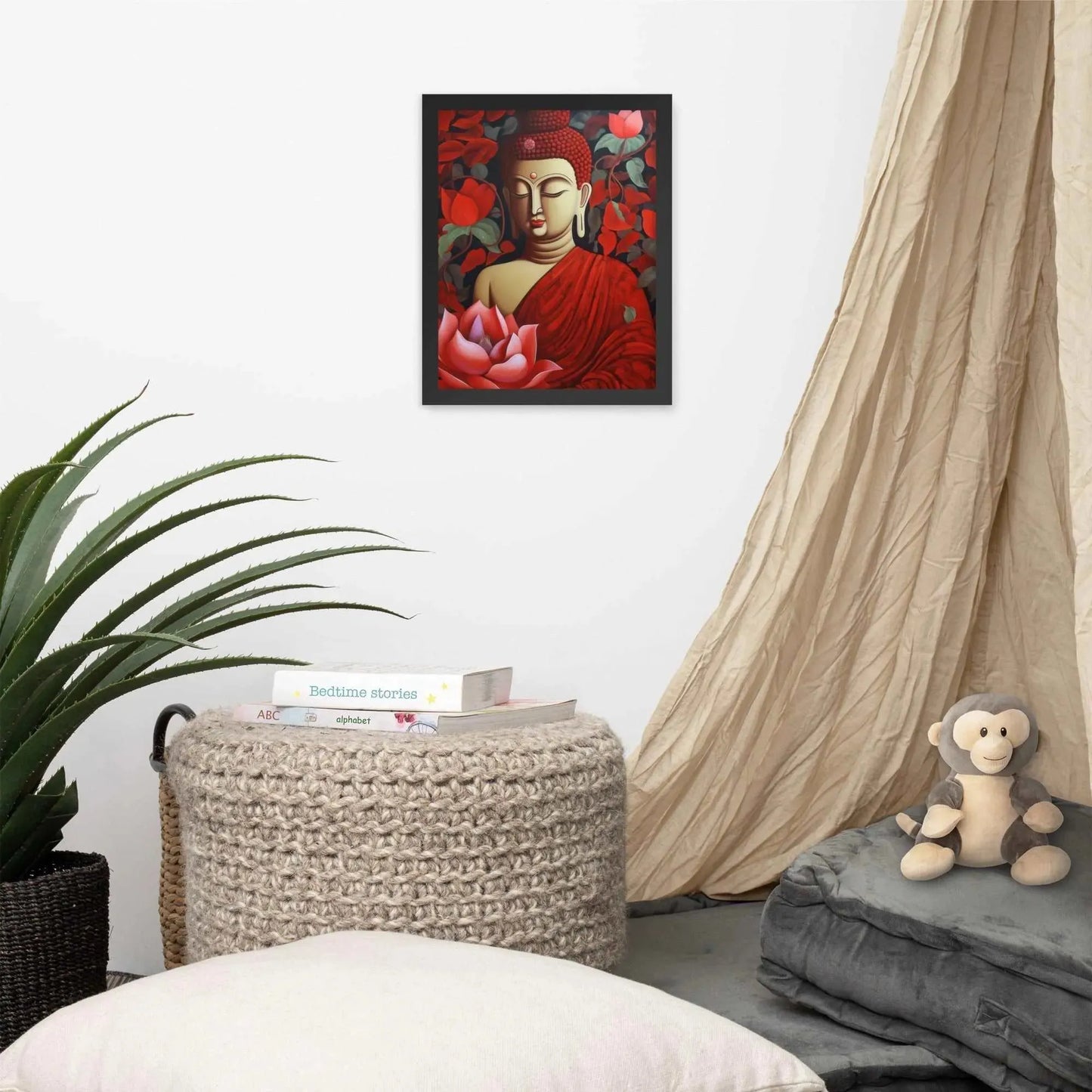 A framed poster of a red Buddha in meditation with a radiant red aura and a large pink lotus flower is set against a backdrop of dark red leaves, creating a peaceful corner in a room with a cozy reading nook, complete with cushions, a woven pouf, and a soft curtain. Nearby, a plush toy monkey adds a touch of playfulness to the tranquil setting.