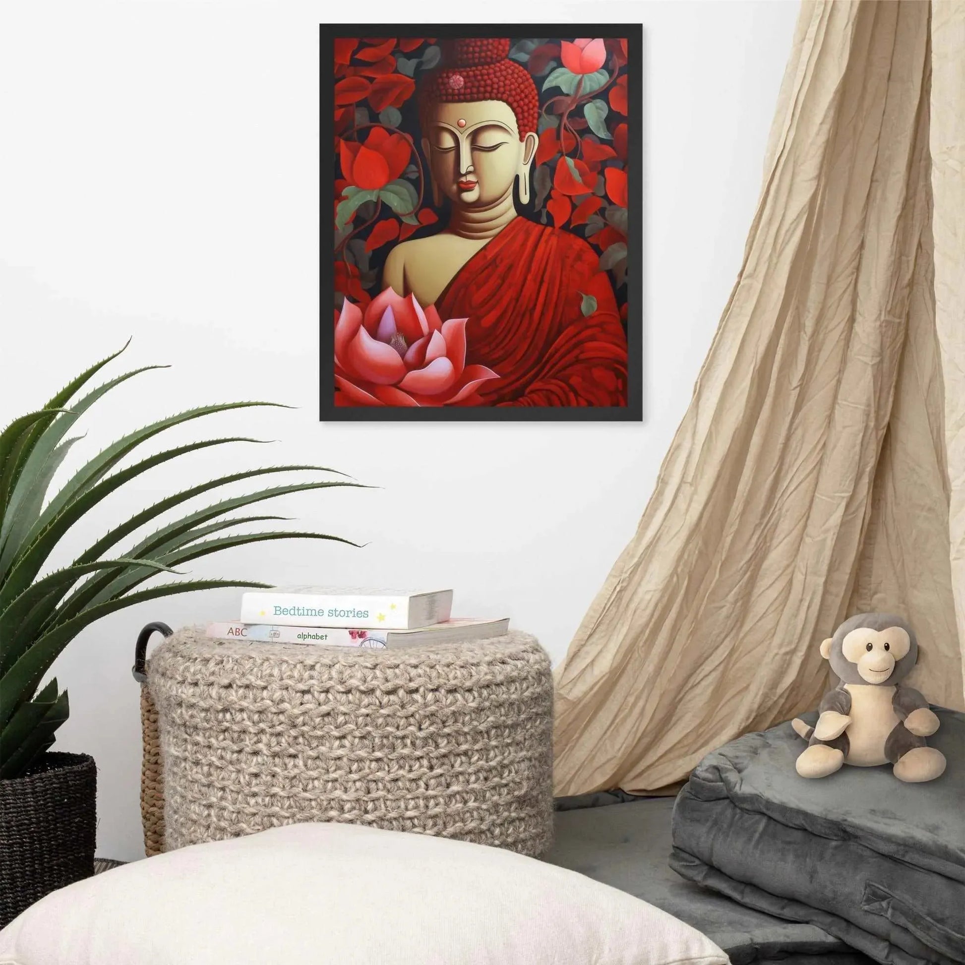 A framed poster of a red Buddha in meditation with a radiant red aura and a large pink lotus flower is set against a backdrop of dark red leaves, creating a peaceful corner in a room with a cozy reading nook, complete with cushions, a woven pouf, and a soft curtain. Nearby, a plush toy monkey adds a touch of playfulness to the tranquil setting.