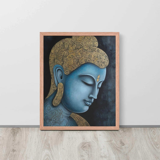 A framed Tibetan Blue Buddha Painting depicts a side profile of a serene, blue-toned Buddha with a golden patterned head, highlighted with a delicate golden ornament on the forehead. The artwork is placed against a dark, smokey background within a red oak frame, resting on a light wooden floor next to a white wall.