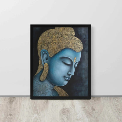 A framed Tibetan Blue Buddha Painting depicts a side profile of a serene, blue-toned Buddha with a golden patterned head, highlighted with a delicate golden ornament on the forehead. The artwork is placed against a dark, smokey background within a black oak frame, resting on a light wooden floor next to a white wall.