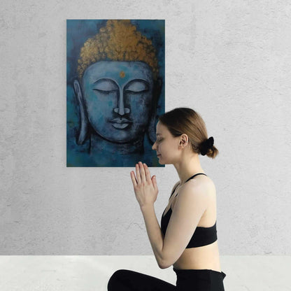 Young woman in a meditative pose before a blue and gold Buddha painting, invoking a sense of calm and spirituality in a minimalist setting.