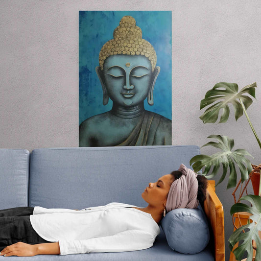 Relaxed woman lying on a blue sofa with a serene blue and gold Buddha head painting on the wall above, complemented by indoor greenery.