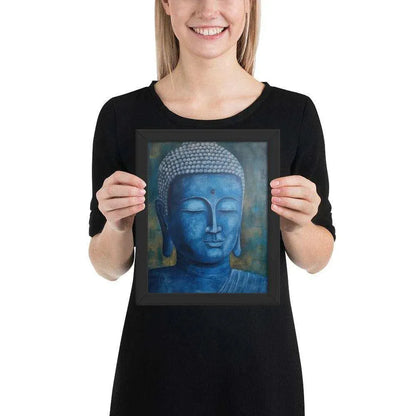 A smiling woman in a black top is displaying a black oak framed poster featuring a serene, monochromatic Blue Buddha Healing Art with a textured background that adds depth to the peaceful visage.